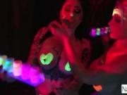 Black-light babes Nadia White and Ophelia suck off a colorful cock