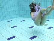 Floating virgin babe swims and strips underwater