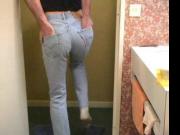 Guy ripping and tearing his pale bue Levi 501 jeans