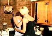 Lesbians French kissing in kitchen