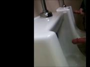 two slim dicks getting wanked at the urinals