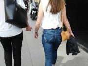 Round ass in blue jeans walking in the street