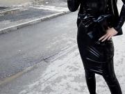 Sexy girl in black latex catsuit walks on street