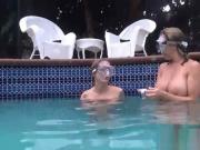 two naked girls breath holding underwater in pool