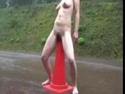girl sitting on signaling cone on the road