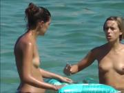 Two Young Women bathing topless at the beach