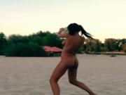 Nude Innuska playing frisbee on the beach