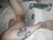 Tattoo MILF pleasing herself in the tub