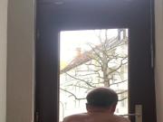 Naked slave cleaning window locked with chain at his balls