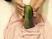 Oiled soles stroking a cucumber