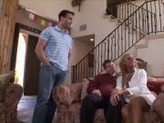 Blonde cougar with big tits rides a young cock on a couch while husband watches