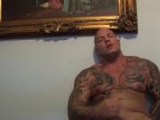 Tattoed muscular stud works out his cock in front of th