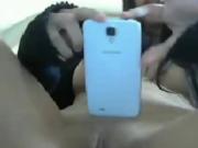 Brunette teen shows her smartphone and pussy