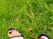 Sweet feet with red toenails in black flip flops