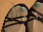 Turquoise toenails show through her tan pantyhose